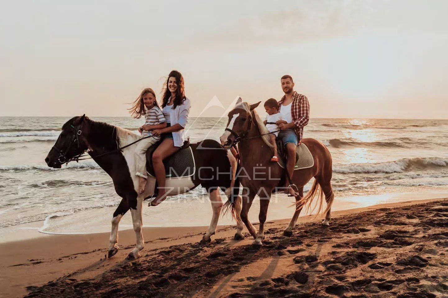 Balade à cheval sur la plage Famille à cheval sur la plage au coucher du soleil