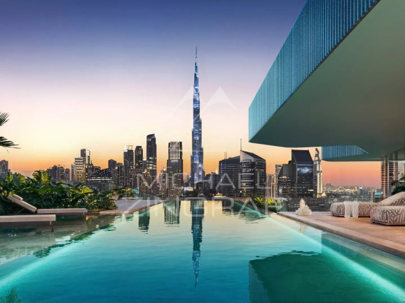 Vue de la piscine d'une résidence à Dubai avec le Burj Khalifa en arrière-plan au crépuscule.