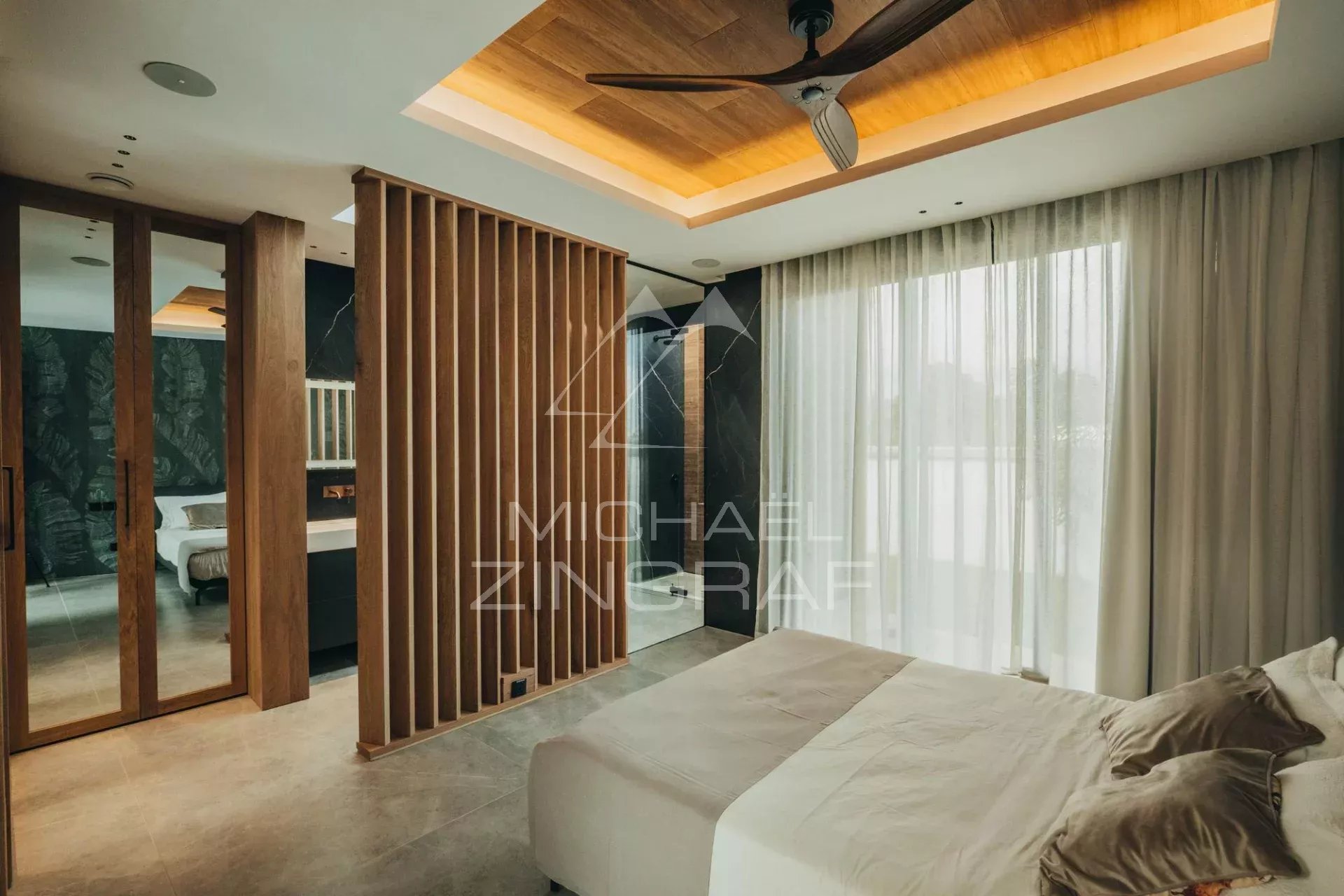 Contemporary room in a luxury villa Modern room with bed, designer lighting and wooden walls, view of the outside.