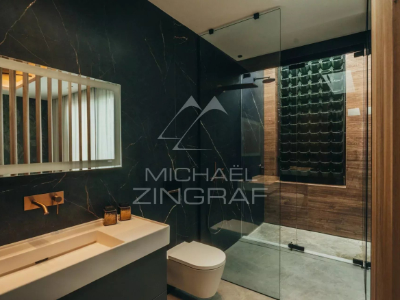 Modern bathroom with glass shower and elegant washbasin, decorated with black marble.