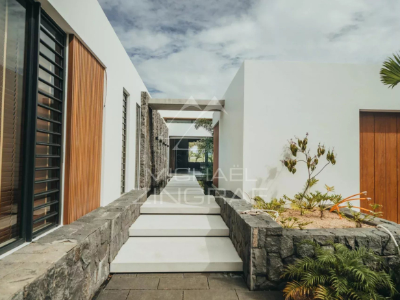 Entrance to a modern villa with garden and stone walls in Haute Rive.