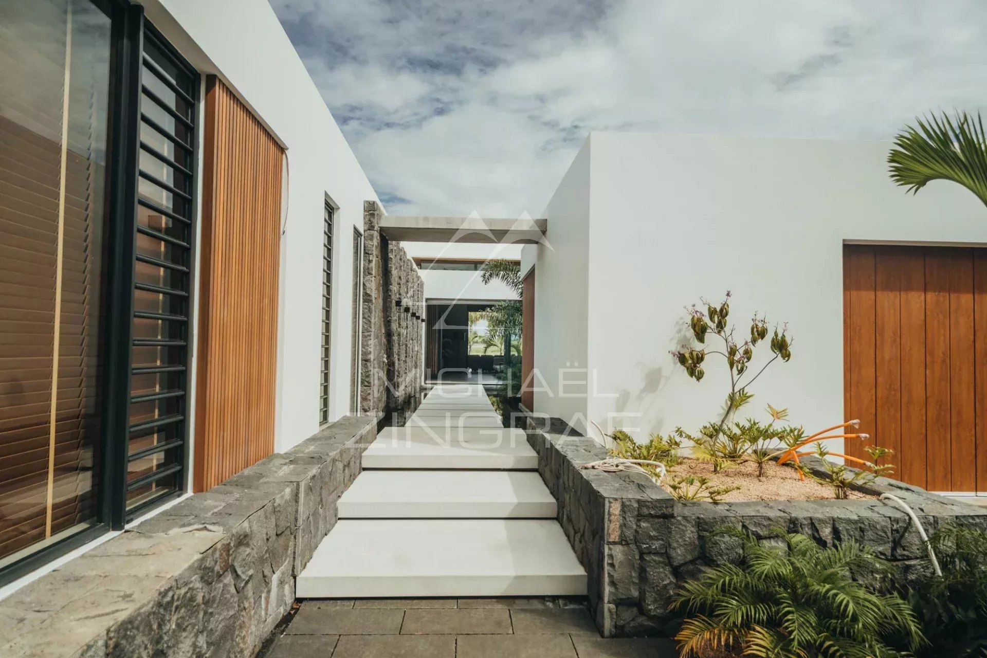Modern villa in Haute Rive Entrance to a modern villa with garden and stone walls in Haute Rive.