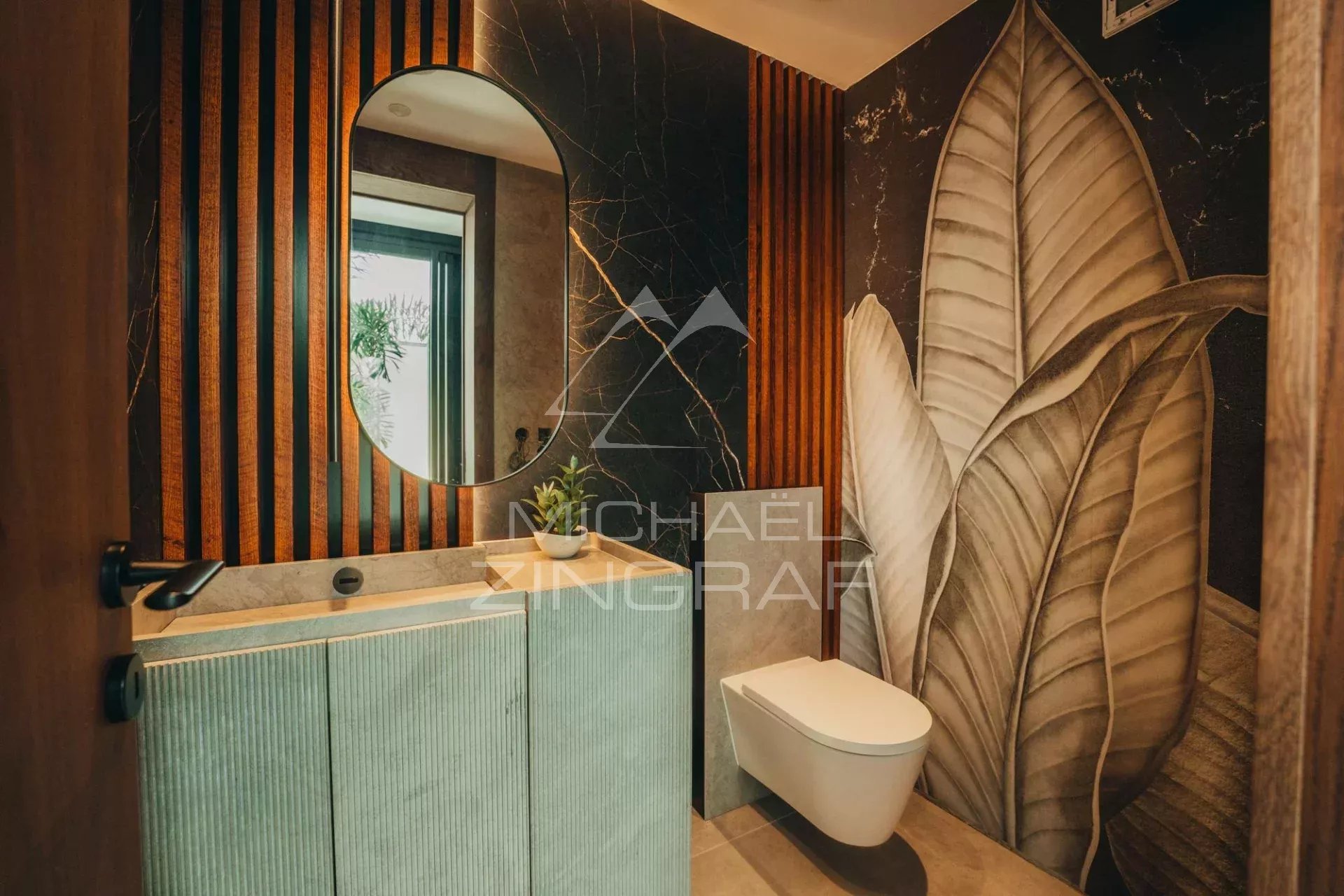 Contemporary bathroom Modern bathroom with round mirror and leaf wall decor.