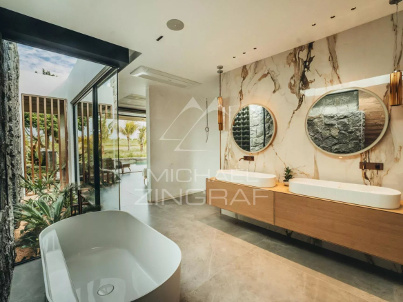 Modern bathroom with bathtub and sinks, natural lighting, view of the outside.