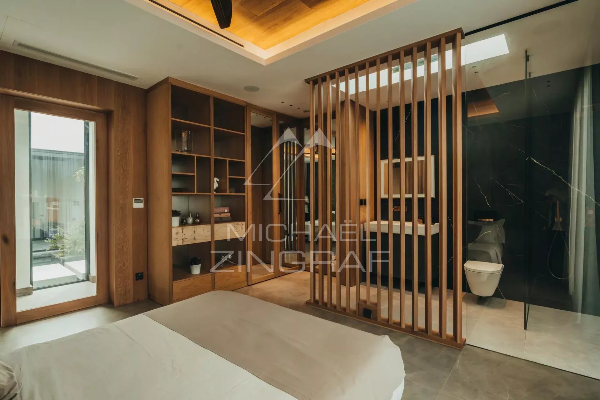 Contemporary villa bedroom Modern bedroom with wooden divider and en-suite bathroom in a contemporary villa.