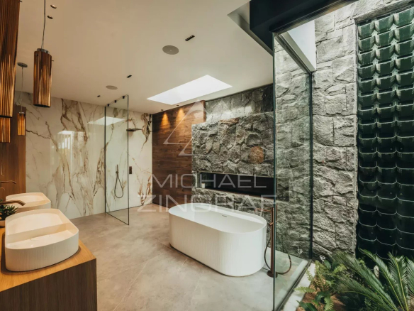 Modern bathroom with bathtub, glass showers and stone walls.