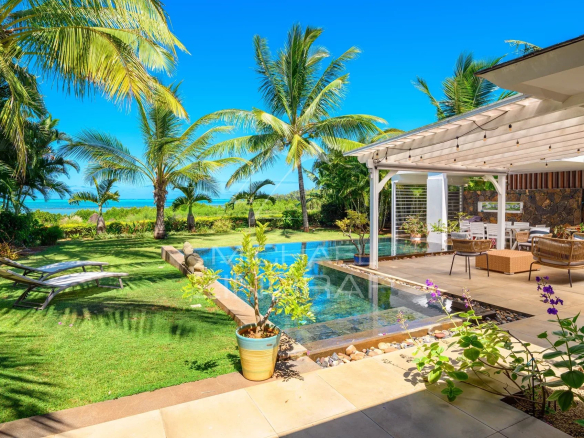 Vue d'une villa en front de mer avec piscine, terrasse et jardin tropical à Haute Rive.