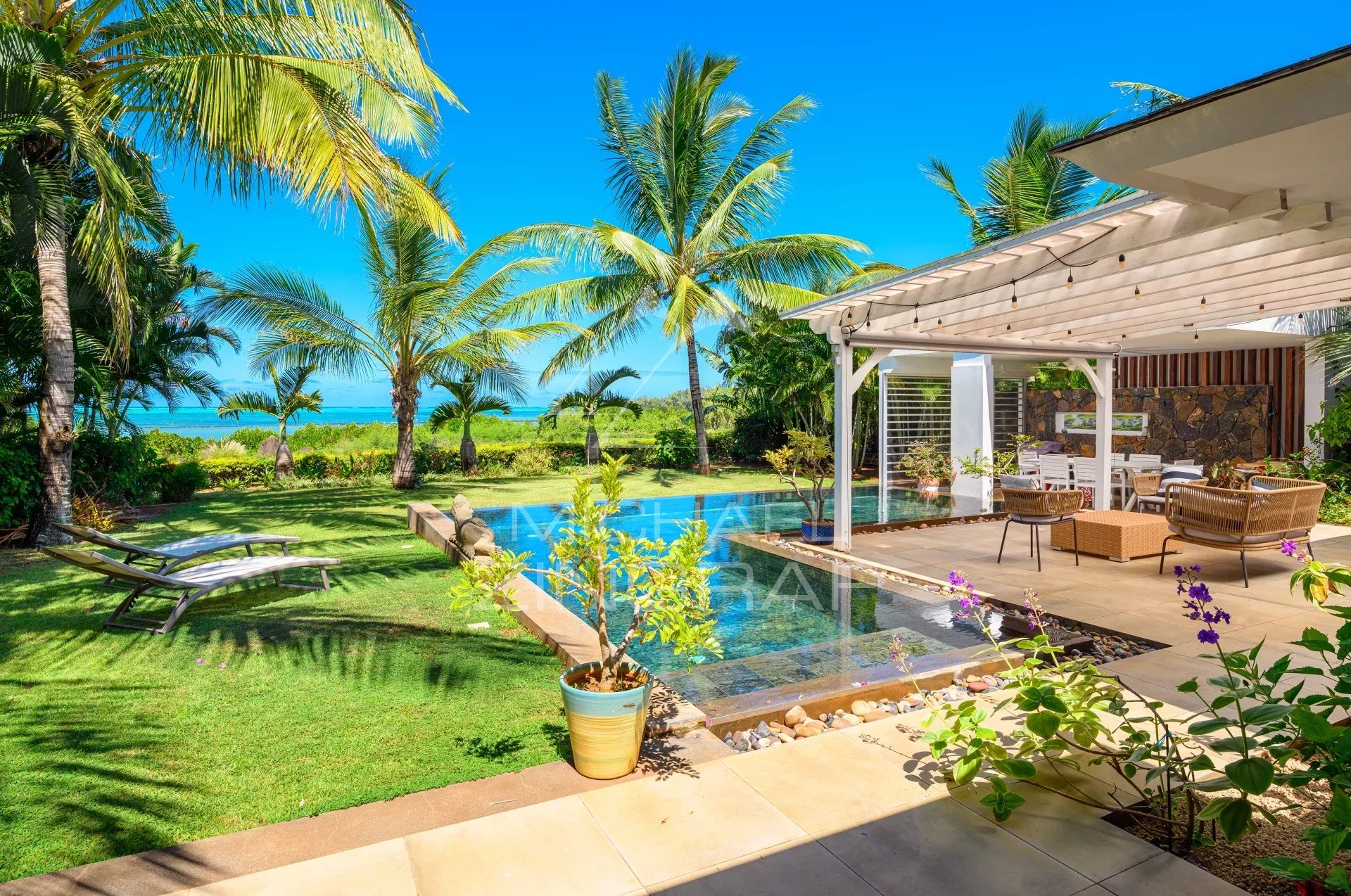 Villa d’Exception à Haute Rive Vue d'une villa en front de mer avec piscine, terrasse et jardin tropical à Haute Rive.