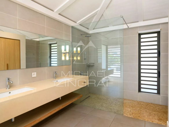 Salle de bain moderne avec lavabo, miroir et douche à l'italienne.