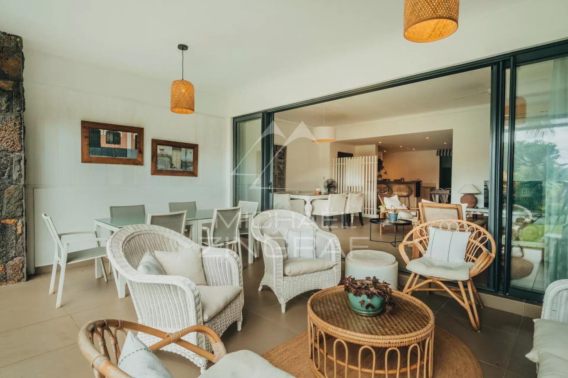 Living room of an apartment in Haute Rive Bright living room of a 3-bedroom apartment with rattan furniture and garden view.