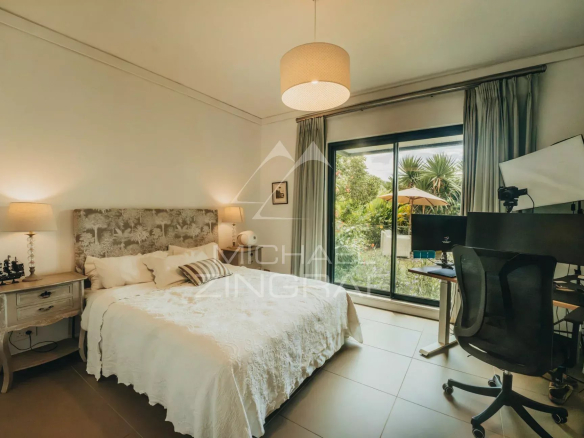 Room in an elegant apartment with a desk and a garden view.