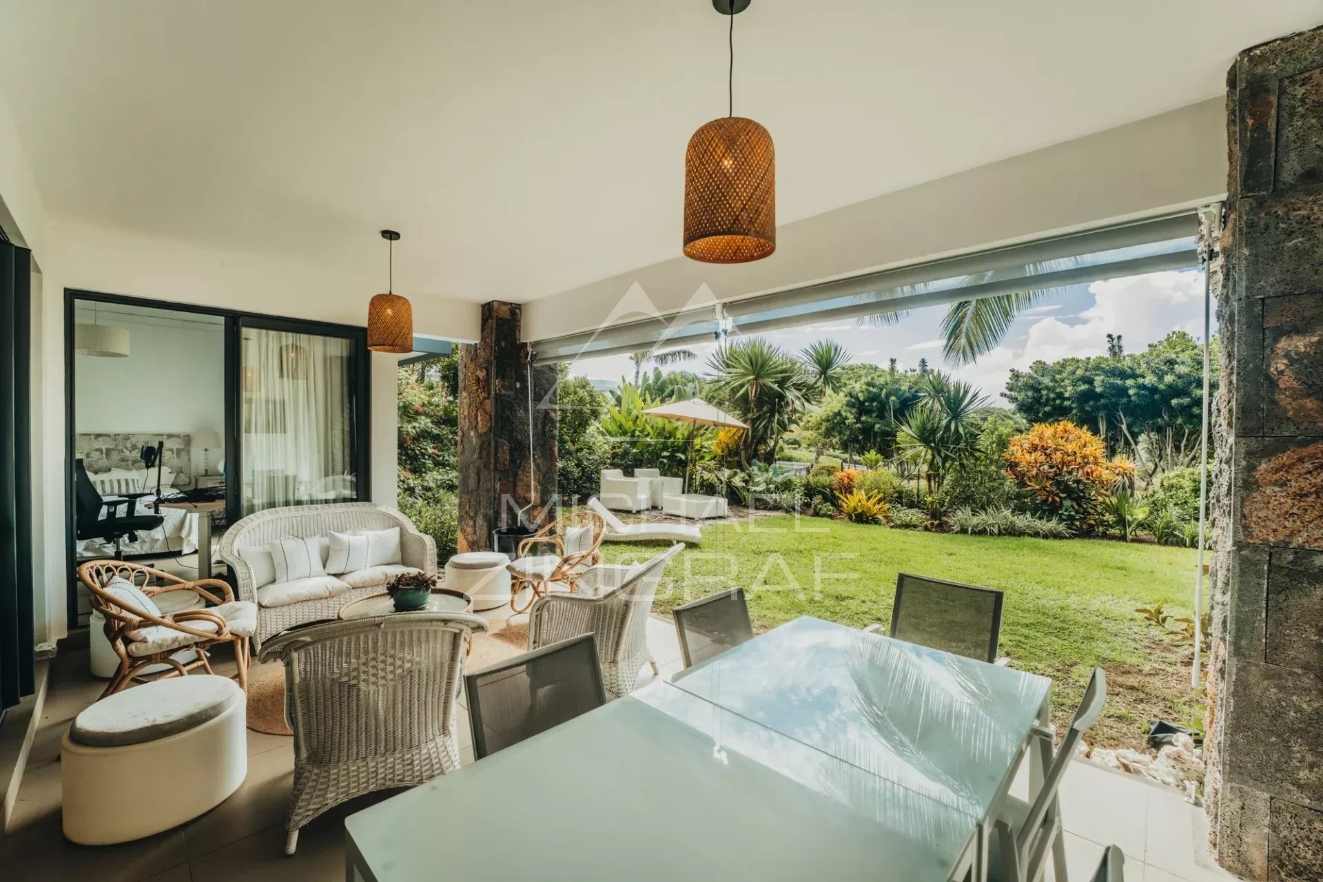 Apartment terrace in Haute Rive Apartment terrace with wicker furniture and view of a landscaped garden in Haute Rive.