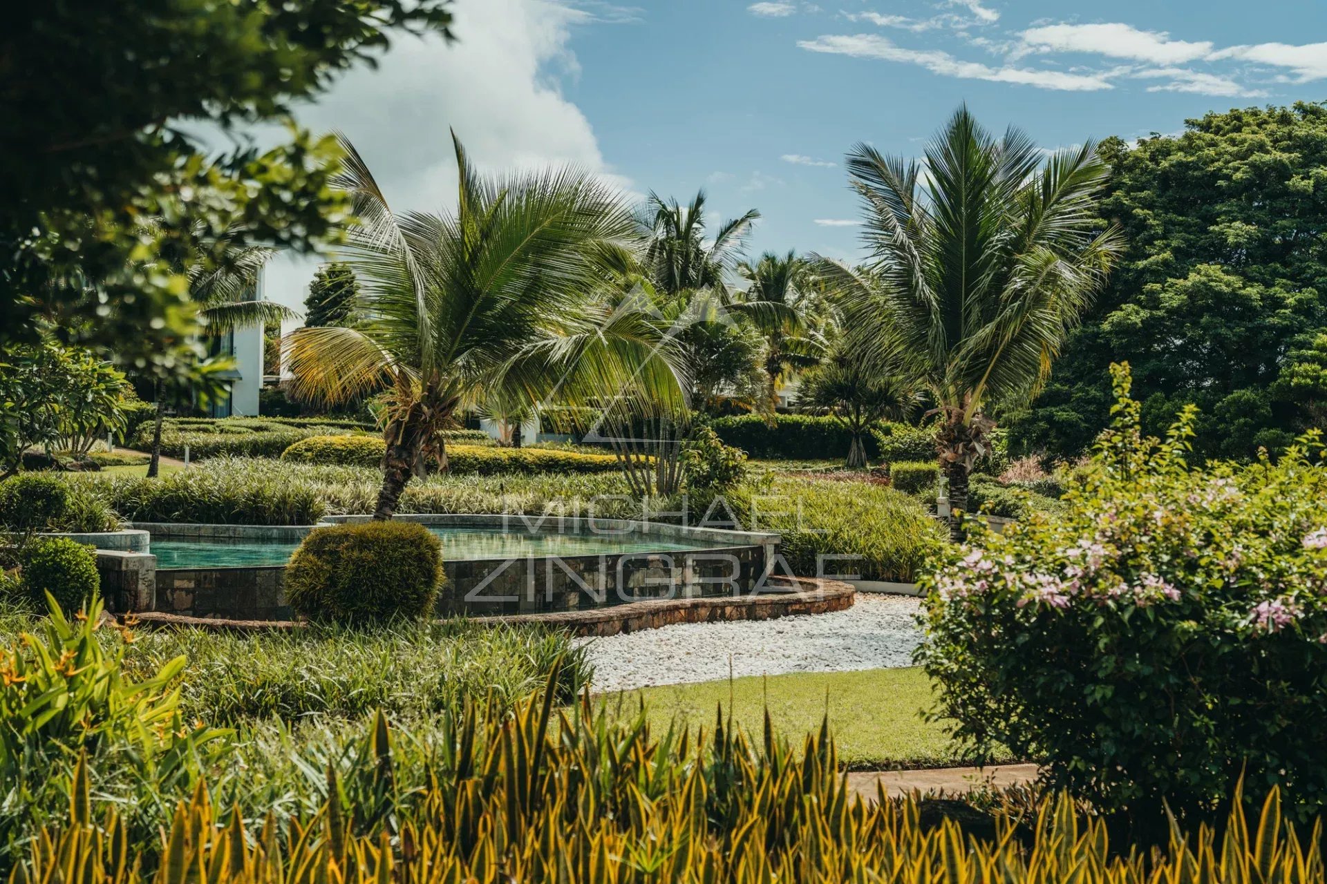 Landscaped garden at Haute Rive Landscaped garden with palm trees and swimming pool in a residential complex in Haute Rive.