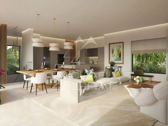 Intérieur d'une villa moderne avec salon et cuisine ouverte, décorée avec des plantes et des meubles contemporains.