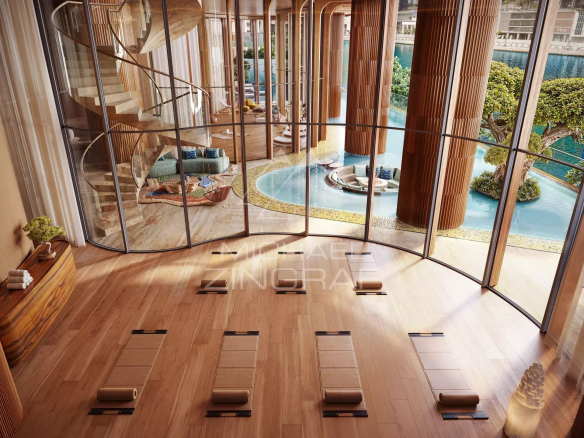 Interior of a wellness area with a view of a pool and gardens, large bay windows.