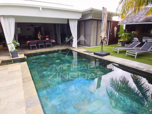 Modern villa with swimming pool in Pereybère, Mauritius, surrounded by greenery and garden furniture.