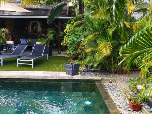 Villa with swimming pool and sun loungers surrounded by greenery in Pereybère.