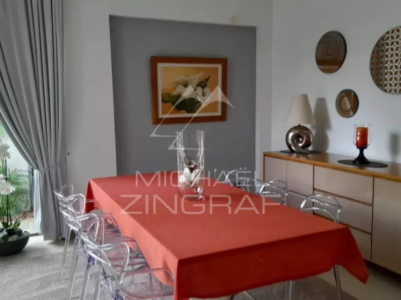 Dining room of a modern villa with a red table and elegant decor.