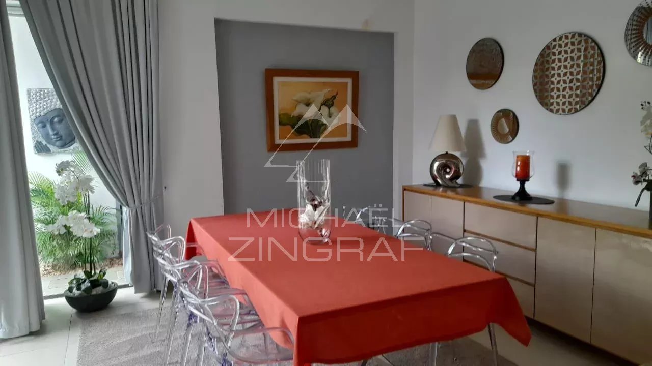 Dining room of the villa in Pereybère Dining room of a modern villa with a red table and elegant decor.