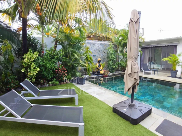 Villa with swimming pool and sun loungers in a lush garden in Pereybère, Mauritius.