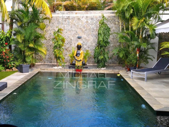 Villa with swimming pool and Buddha statue in a garden in Pereybère.