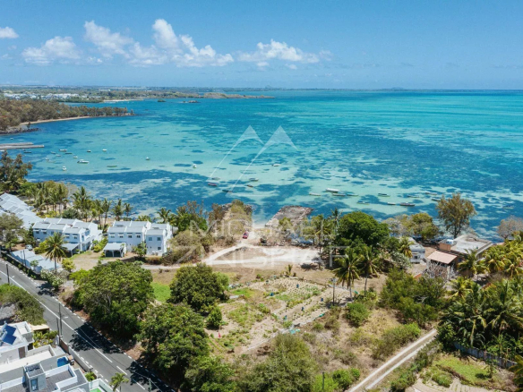Aerial view of Roches Noires with turquoise sea and boats, surrounded by vegetation.