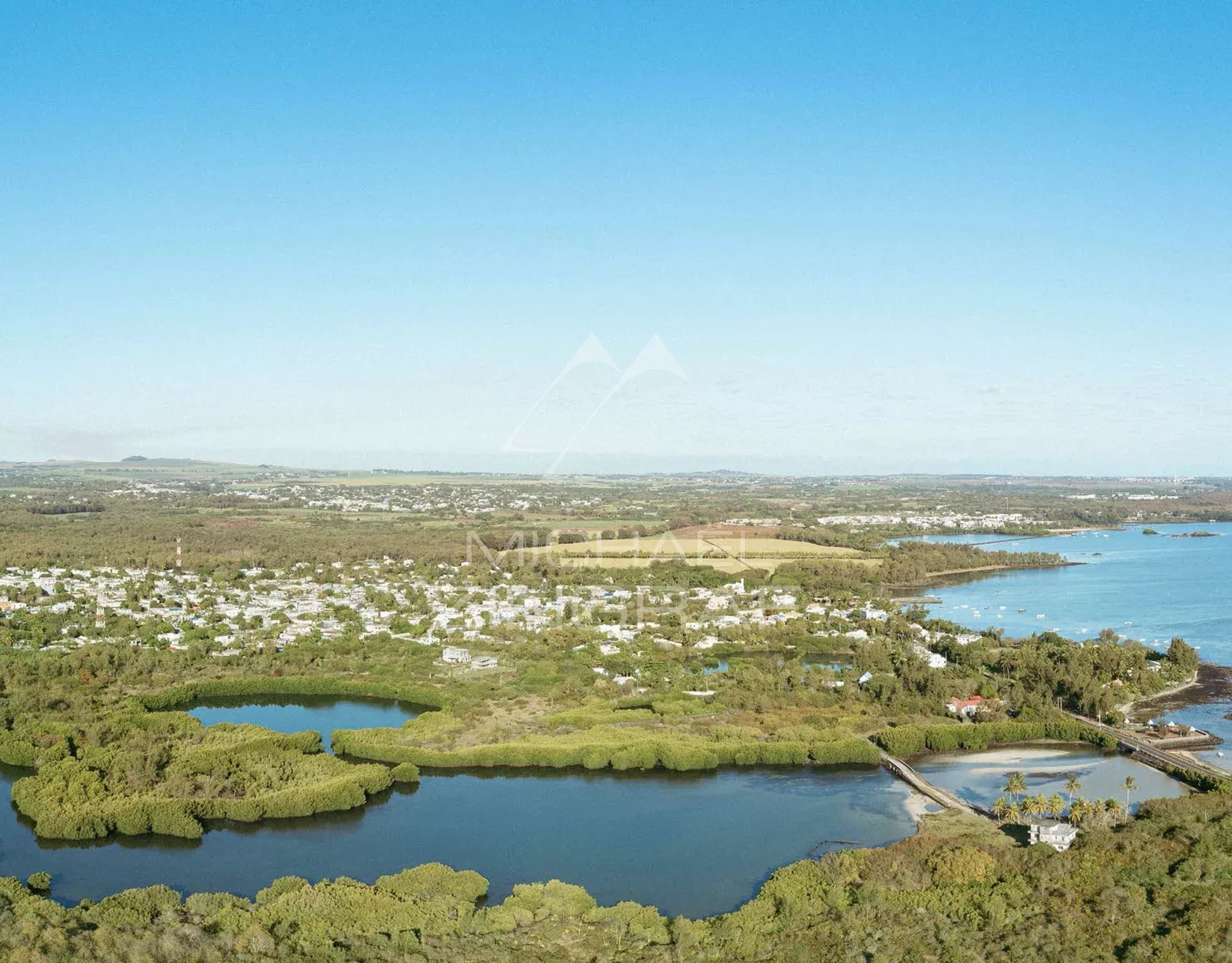 Aerial view of Roches Noires with lagoons and lush green nature.