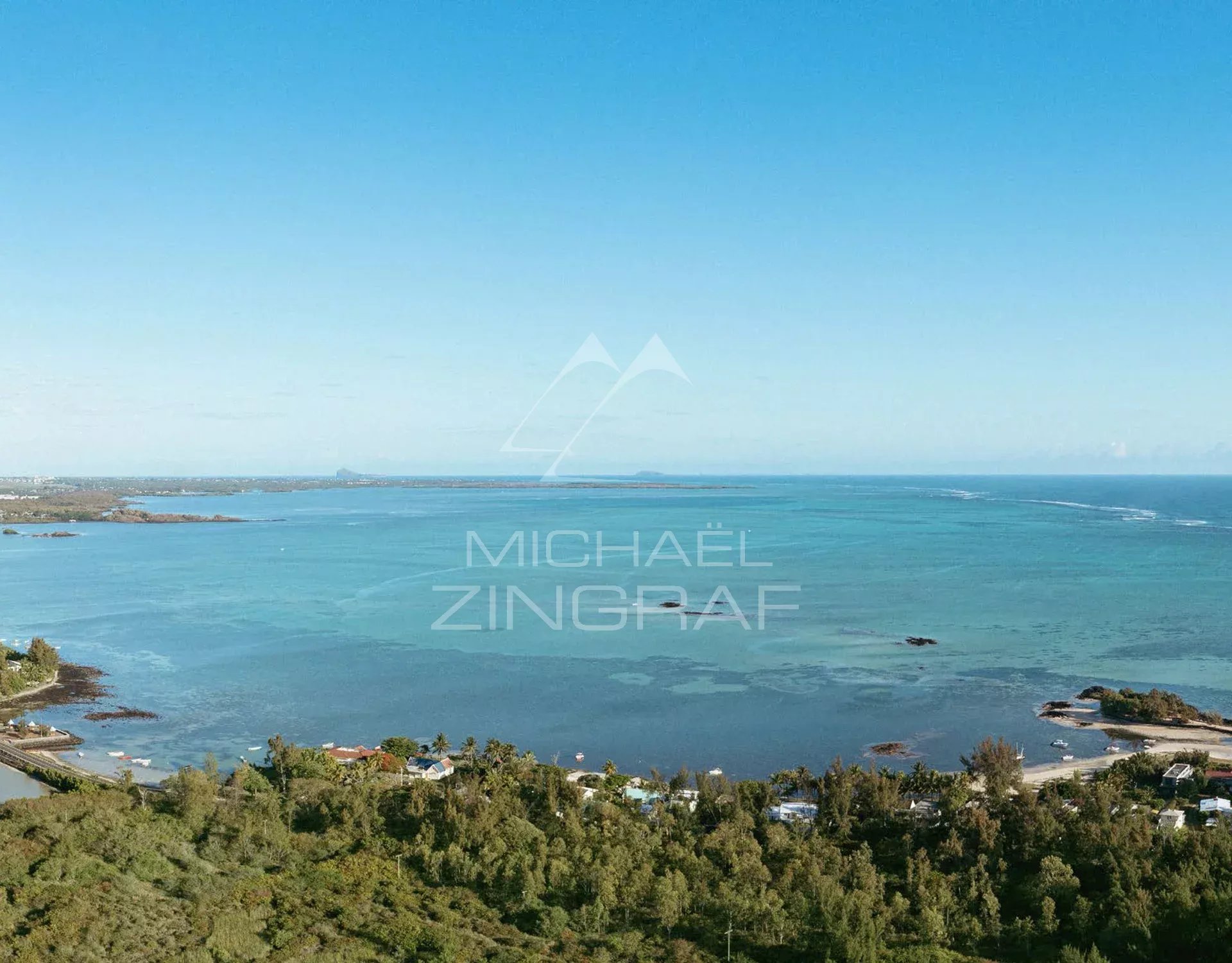 Panoramic ocean view at Roches Noires, with verdant landscapes in the foreground.
