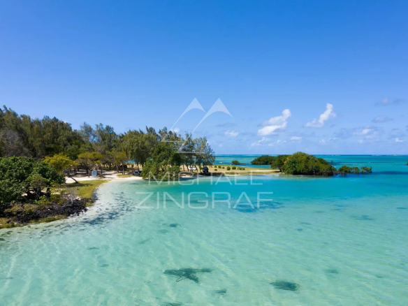 Panoramic view of a beach with turquoise water and vegetation at Roches Noires.