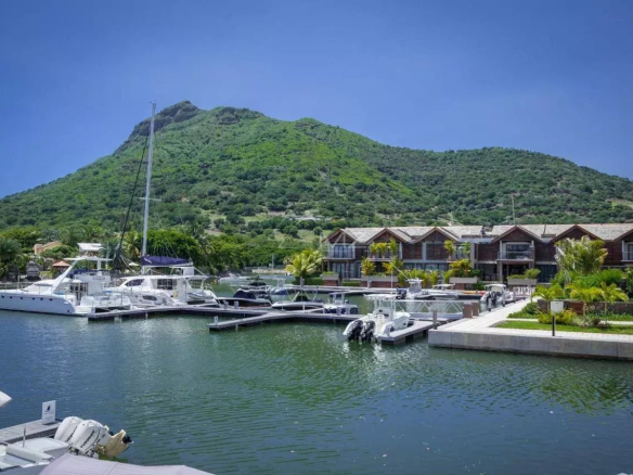 Vue sur La Balise Marina avec yachts et montagnes en arrière-plan.