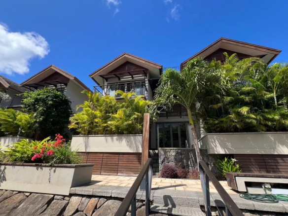 Duplex à La Balise Marina avec terrasse et végétation luxuriante.