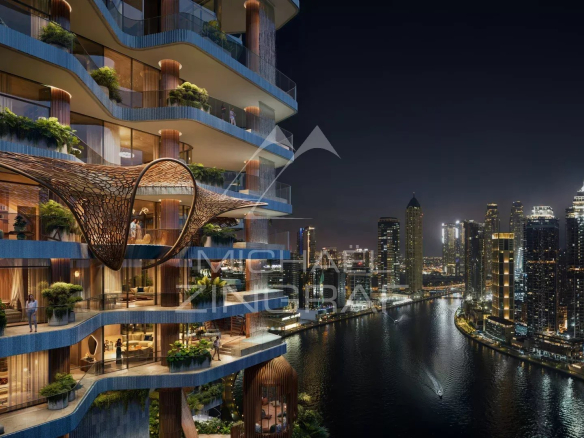 Night view of a luxury apartment in Dubai with balconies and lighting overlooking the Dubai Water Canal.
