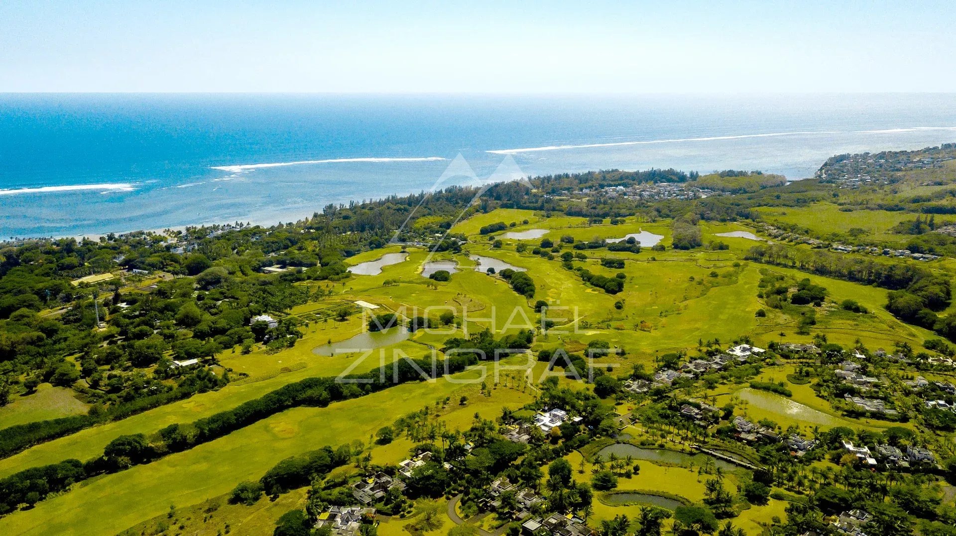 Vue aérienne des villas de luxe à Heritage Villas Valriche, Bel Ombre, avec la mer en arrière-plan.