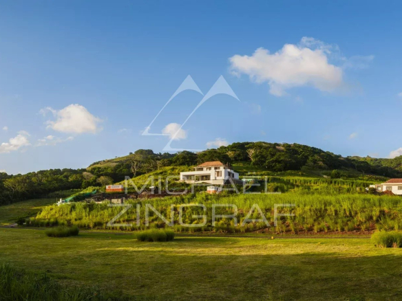 Villas de luxe dans un domaine privé à Bel Ombre, île Maurice, avec des collines verdoyantes en arrière-plan.