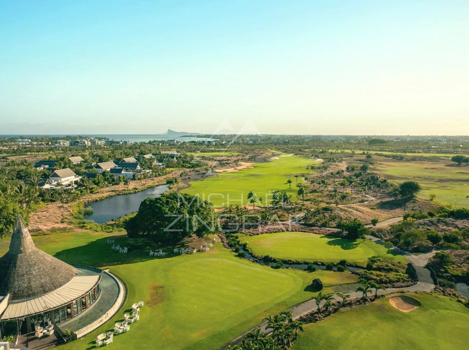 Domaine de golf de Mont Choisy Vue aérienne du domaine de golf de Mont Choisy avec des villas et un paysage verdoyant.
