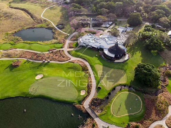 Vue aérienne du domaine de golf de Mont Choisy avec son club-house et ses parcours verdoyants.