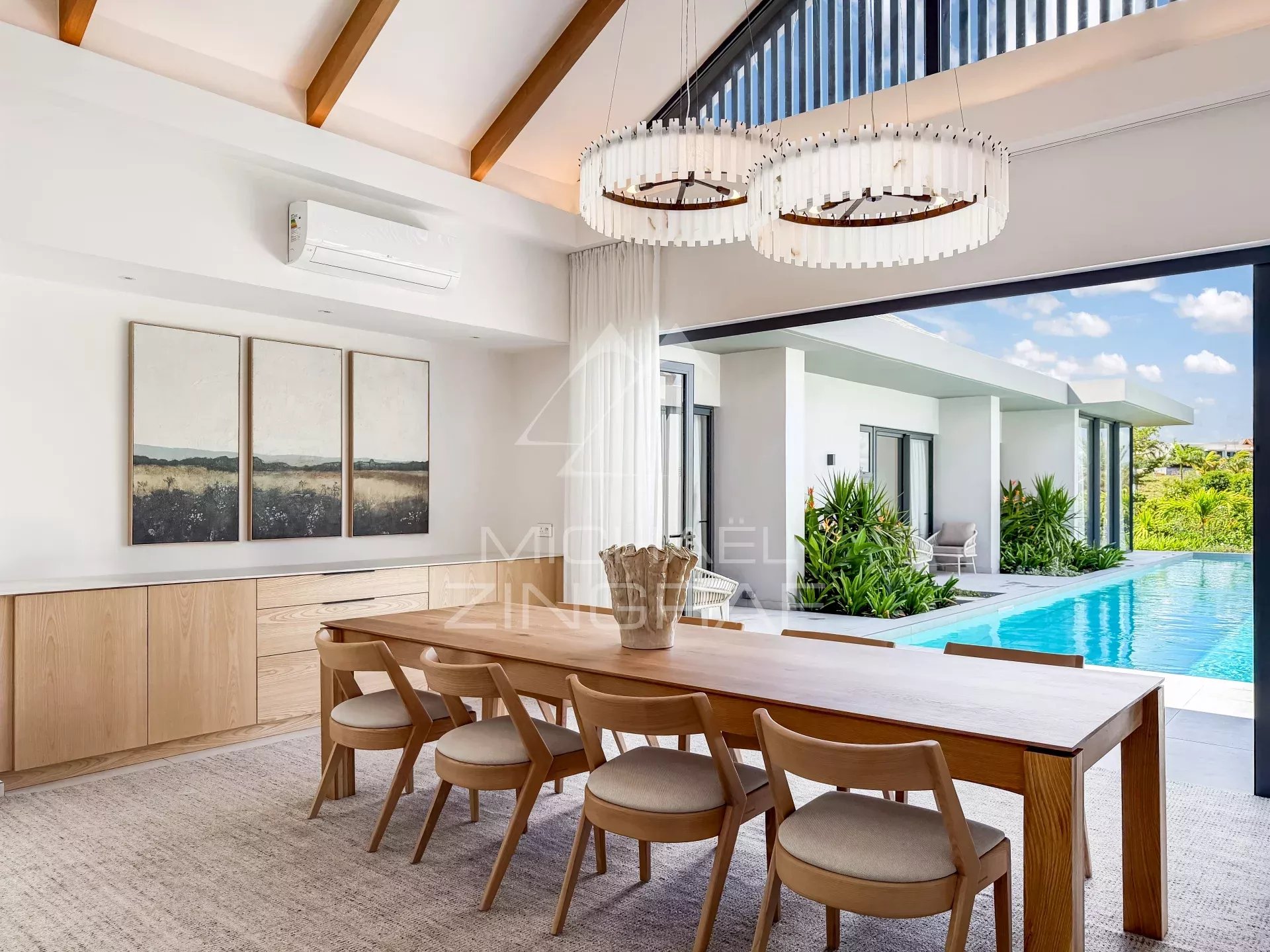 Intérieur d’une villa à Mont Choisy Golf Estate Intérieur d'une villa moderne avec salle à manger et vue sur la piscine.