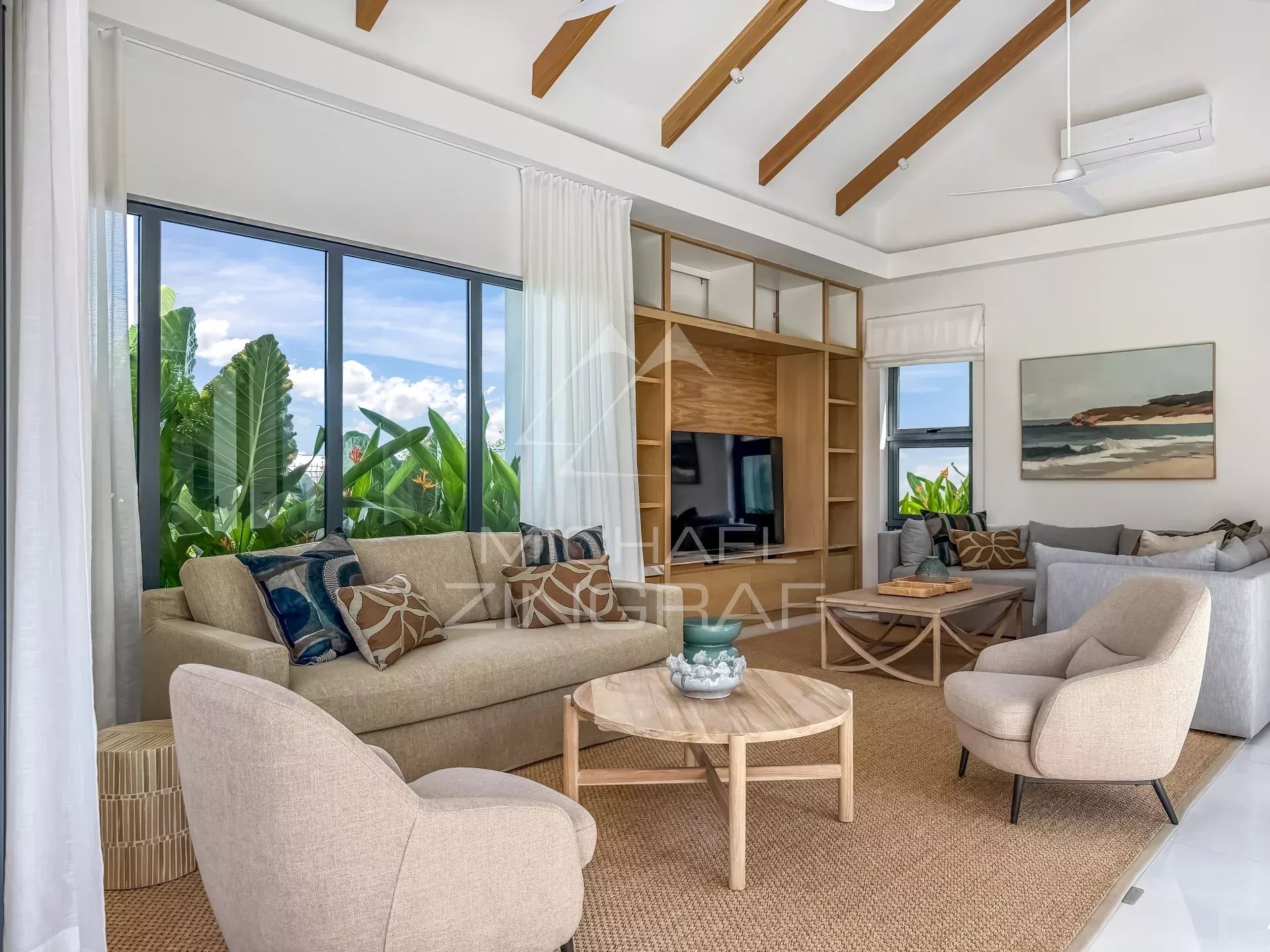 Salon d’une villa au Mont Choisy Golf Estate Intérieur d'une villa moderne avec un salon lumineux et des grandes fenêtres, décoré avec des meubles contemporains.