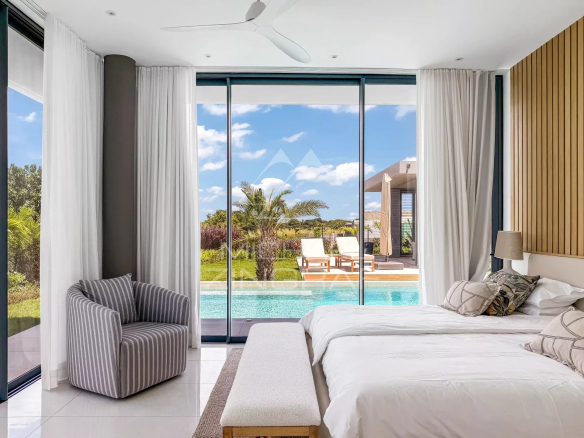 Chambre lumineuse avec vue sur piscine et jardin dans une villa à Mont Choisy Golf Estate.