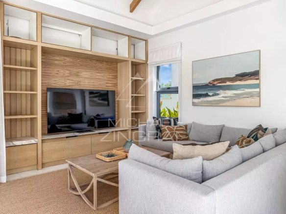 Intérieur d'une villa moderne avec un salon confortable et une télévision.
