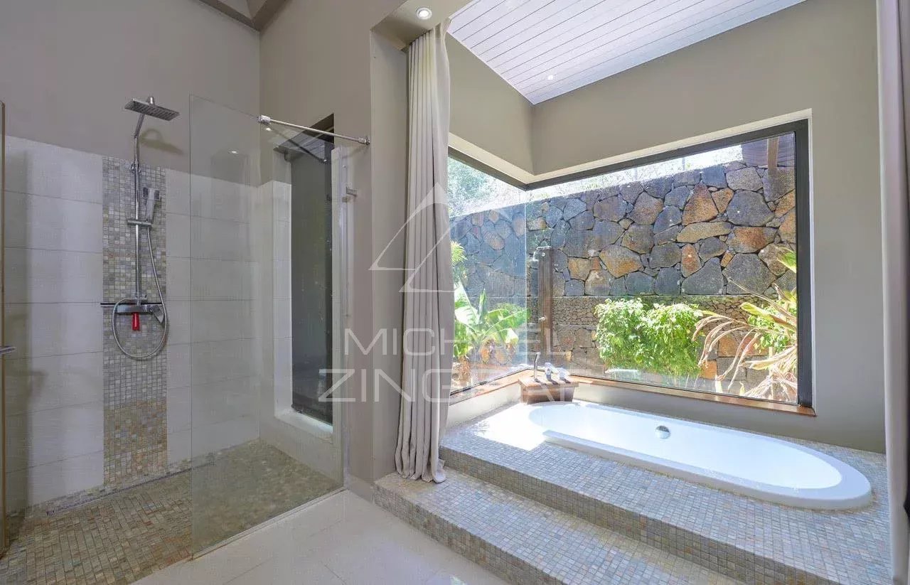 Salle de bain moderne Salle de bain moderne avec douche et baignoire, vue sur un jardin.
