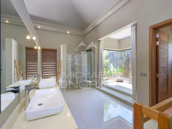 Salle de bains moderne avec douche et lumière naturelle, villa à Grand Baie.
