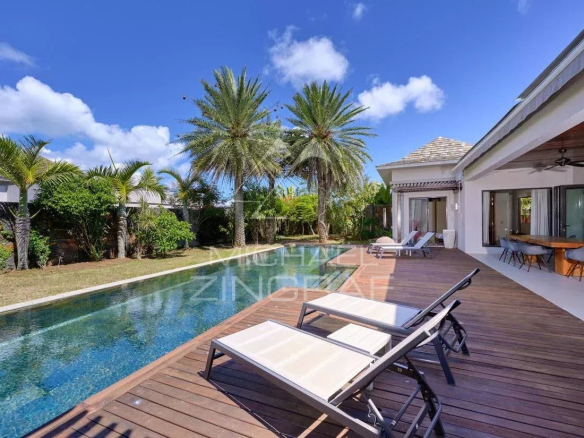 Villa moderne avec piscine privée et chaises longues, entourée de palmiers à Grand Baie.