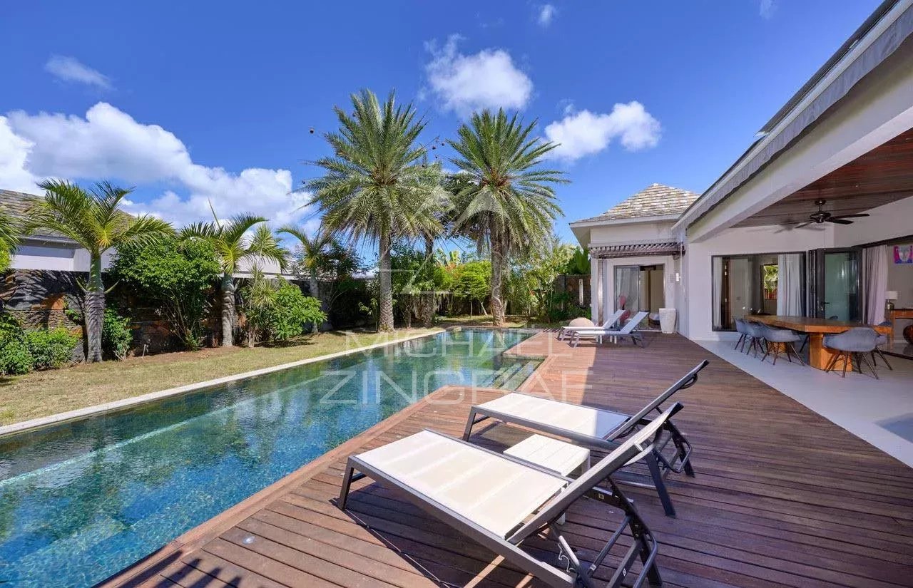 Villa d’exception à Grand Baie Villa moderne avec piscine privée et chaises longues, entourée de palmiers à Grand Baie.