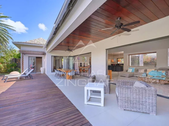 Villa moderne avec piscine privée et terrasse en bois, entourée de verdure à Grand Baie.