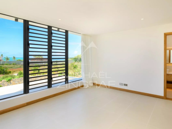 Intérieur d'une villa moderne avec fenêtre et vue sur le jardin.