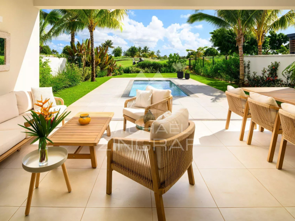 Terrasse d'une villa jumelée à Azuri avec salon extérieur et piscine, vue sur le jardin et le golf.