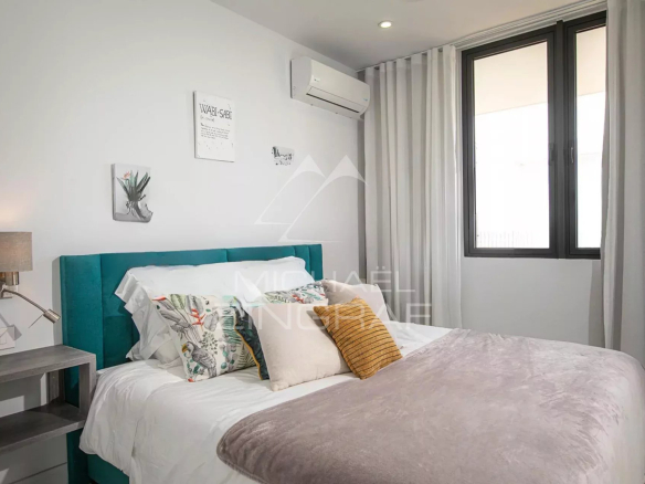 Chambre d'une villa de luxe avec lit double et décoration moderne à Haute Rive.