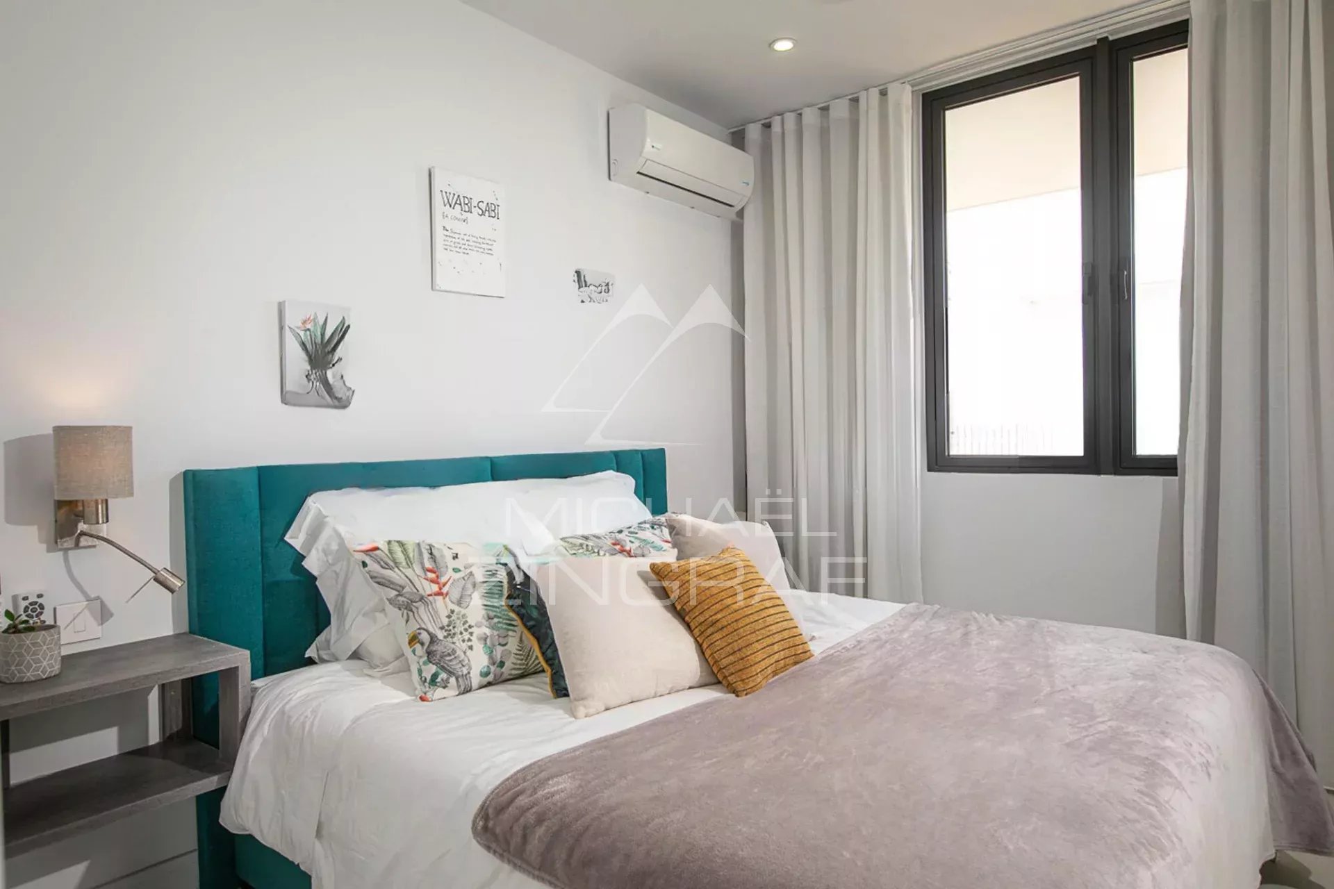 Chambre d'une villa de luxe avec lit double et décoration moderne à Haute Rive.