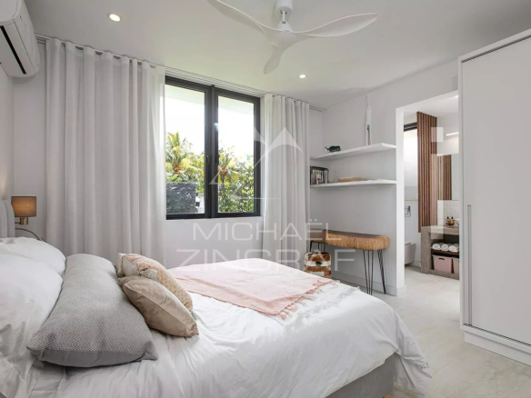 Chambre d'une villa de luxe avec lit, fenêtres et décoration moderne.
